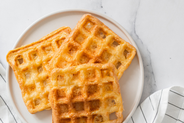 Gaufres Keto dorées empilées sur une assiette avec une garniture de fruits rouges