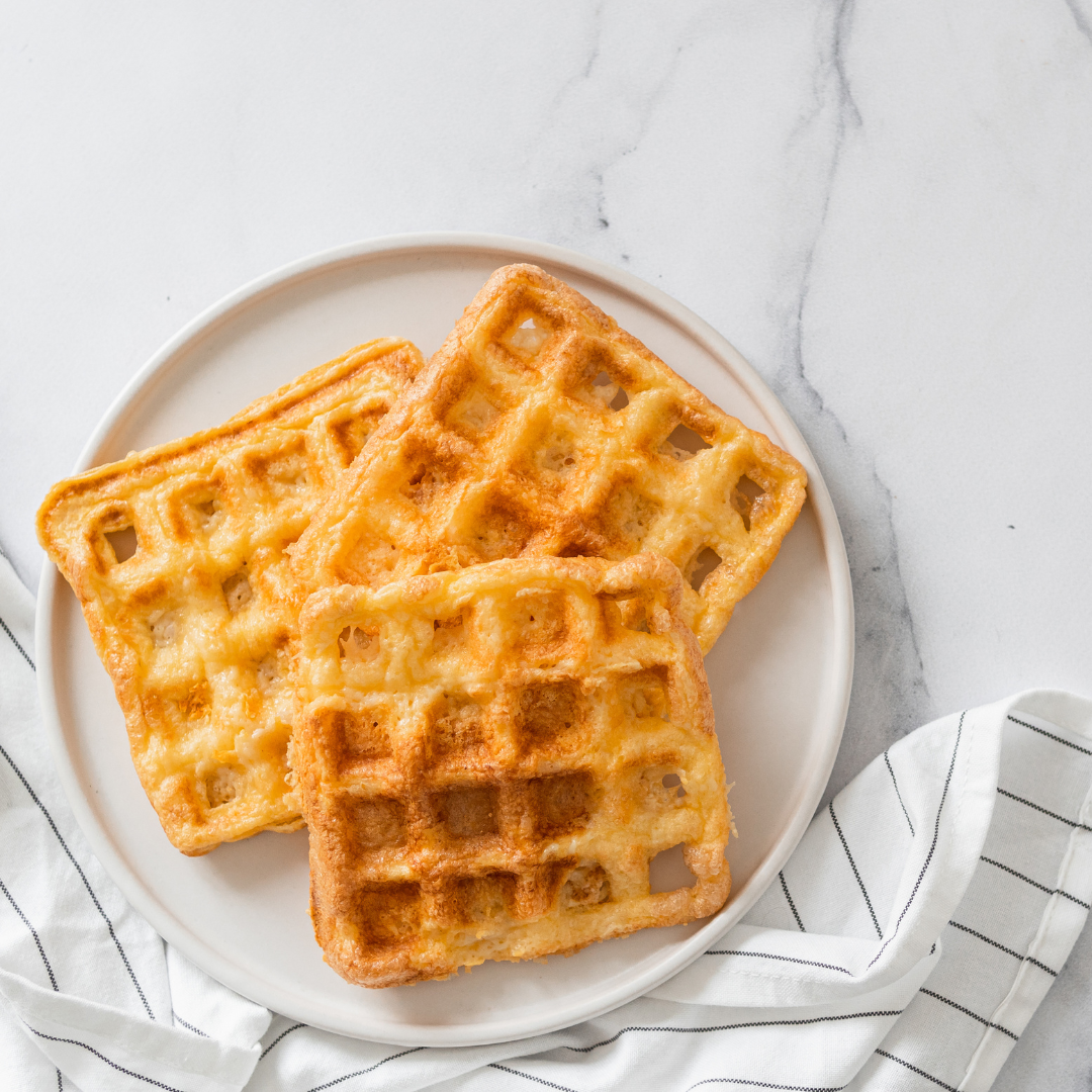 Gaufres Keto dorées empilées sur une assiette avec une garniture de fruits rouges